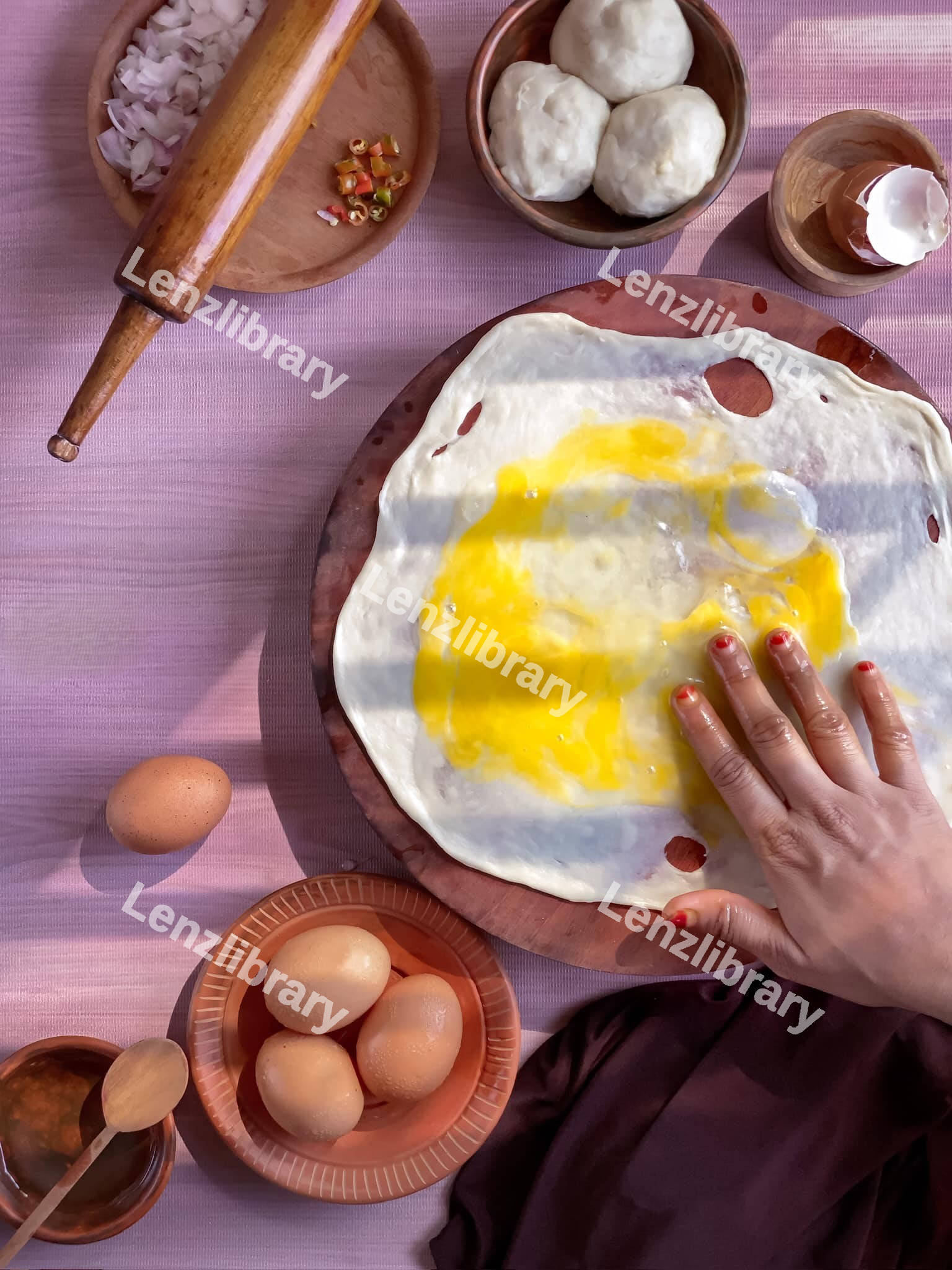 Female hands mixing an egg over dough